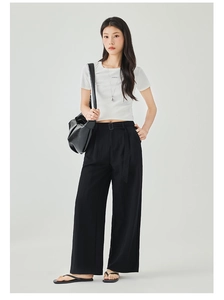Dettaglio dei pantaloni neri a gamba larga a vita alta con cintura coordinata