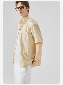 Dettaglio camicia beige chiaro a maniche corte con colletto classico e taschino