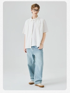 Camicia uomo bianca a maniche corte abbinata a jeans larghi azzurri lavati