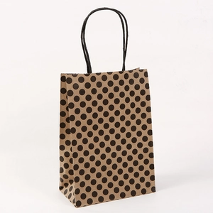 Close-up of brown kraft paper gift bag with black polka dots and rope handles
