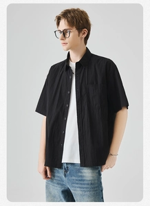 Dettaglio di una camicia nera a maniche corte con tessuto testurizzato e t-shirt