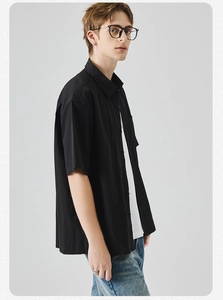 Dettaglio della camicia casual nera a maniche corte con tessuto strutturato e colletto a rever