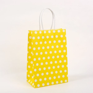 Sac cadeau en papier kraft jaune à pois blancs avec poignées en cordon torsadé blanc