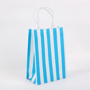 Detail of blue and white striped paper gift bag with serrated edges and sturdy white handles