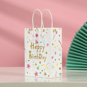Detailed view of white paper gift bag with golden Happy Birthday text and party icons