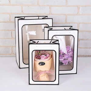 Three sizes of white windowed flower gift bags with black borders and handles