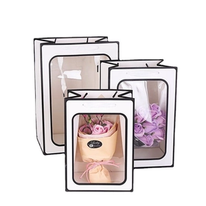 Three-piece set of white gift bags with large transparent windows and black trim