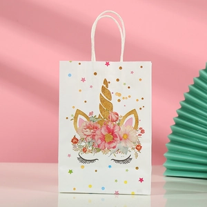 Detailed view of white unicorn gift bag with glitter horn and floral crown design