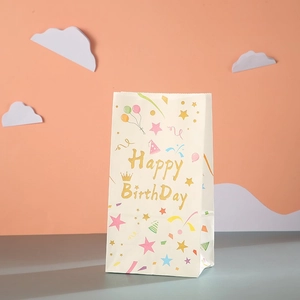 Detail of white Happy Birthday gift bag with gold lettering and colorful party patterns