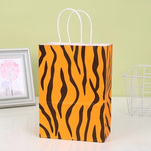 Close-up of tiger stripe kraft paper party gift bag with white rope handles and zigzag edges