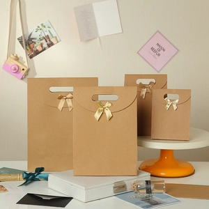 Brown kraft paper gift bags with champagne satin bows in four various sizes