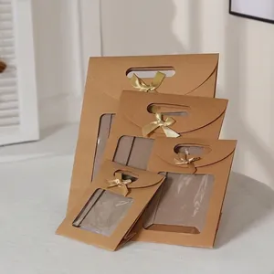 Brown kraft paper gift bags with clear window and gold ribbon bows in four sizes