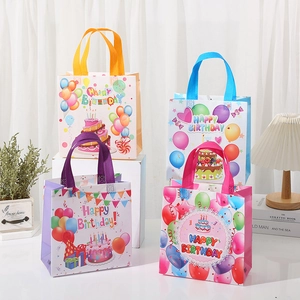 Detalle de cuatro bolsas de regalo coloridas de tela no tejida con globos y pasteles de cumpleaños