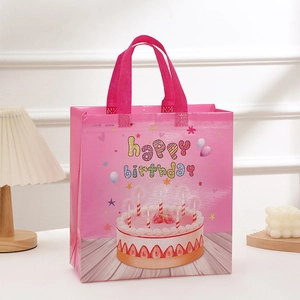 Pink non-woven birthday gift bag with colorful cake print and happy birthday text