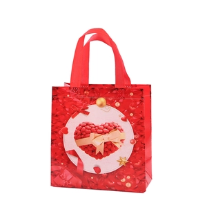 Sac cadeau Saint-Valentin en intissé rouge avec motif cœur, nœud doré et décor de perles