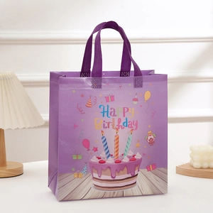 Detailed view of purple Happy Birthday non-woven gift bag with colorful cake print