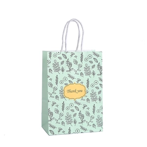 Sac cadeau vert menthe aux motifs floraux avec étiquette Thank You et anses blanches