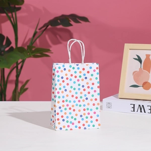 Polka dot paper gift bag with colorful circles and twisted handles for party favors