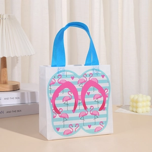 Detail of summer style non-woven gift bag with blue handles and flamingo pattern