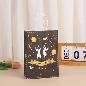 Graduation party gift bag with 'I'M DONE' text and silhouettes on black kraft paper
