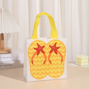 Detail of white non-woven gift bag with yellow handles and flip-flop beach print