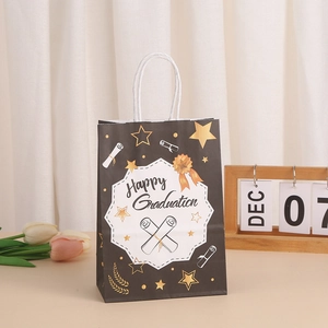 Elegant black Happy Graduation gift bag with gold stars and white woven handles