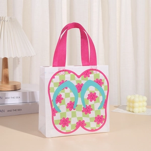 Detail of waterproof non-woven tote bag with flip-flop print and pink woven handles