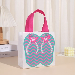 Close-up of white non-woven gift bag with pink handles and cute bow heart patterns