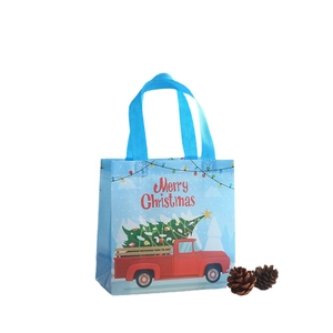 Blue non-woven Christmas gift bag with a red truck and Merry Christmas festive print