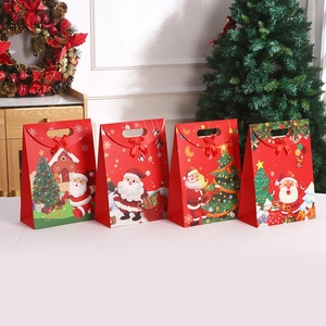 Set of four red Christmas kraft paper gift bags with ribbons and festive cartoon patterns