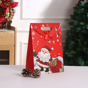 Red Christmas kraft paper gift bag with Santa Claus motifs and a festive ribbon bow