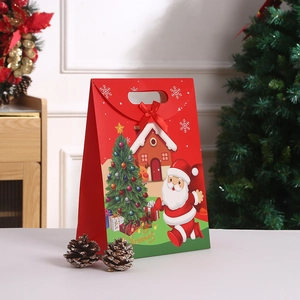 Detail of red Christmas kraft gift bag with Santa Claus print and ribbon bow handle