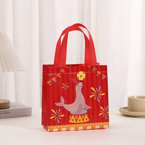 Détail du sac cadeau non tissé rayé rouge avec imprimé otarie de cirque et anses ruban