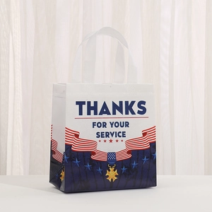 Veterans Day non-woven gift bag with American flag and medal design on white desk