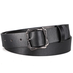 Detail view of black textured leather belt with gunmetal square buckle on white backdrop