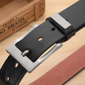 Close-up of black leather belt with brushed silver square buckle on a rustic wooden background