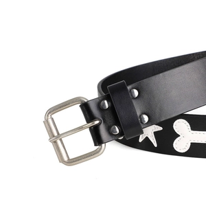 Detail of black leather belt featuring white star and bone patterns with silver buckle