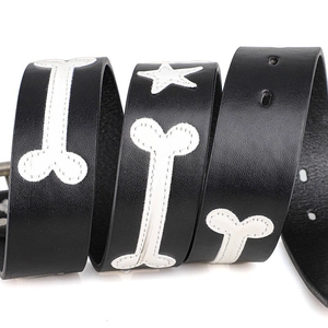 Black leather belt with white bone and star patterns featuring metallic buckle for jeans