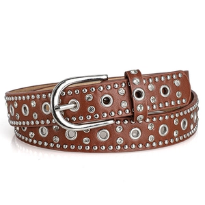 Detail of punk leather belt with silver studs, rhinestones, and metal eyelets on white background