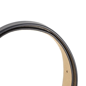 Macro detail of black grained leather belt edge showing stitching and tan inner layer