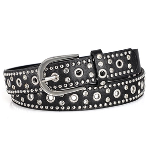 Close-up of black punk belt with silver rivets, rhinestones and metal eyelets on white