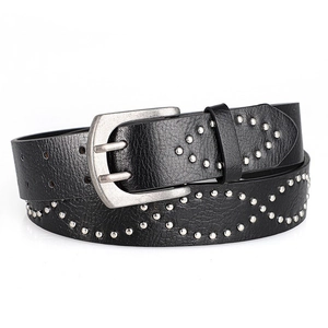 Detail of black leather punk belt with silver rivets and vintage buckle close-up view