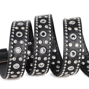 Close-up of black punk belt with silver rivets, eyelets and sparkling rhinestones