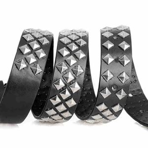 Détail macro de la ceinture punk en cuir noir avec trois rangées de clous pyramide