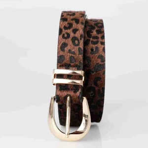 Détail d'une ceinture léopard en poil de poney avec boucle dorée en forme de fer à cheval