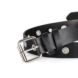 Detail of punk style black leather belt with silver metal grommets and square buckle