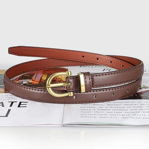 Detail of dark brown leather slim belt with golden horseshoe buckle and red stitching