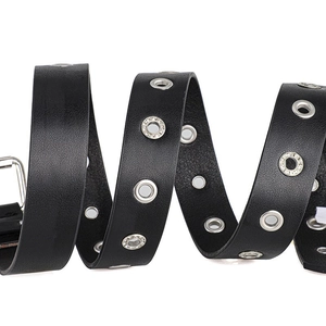 Macro detail of punk black leather belt with silver eyelets and sparkling rhinestones