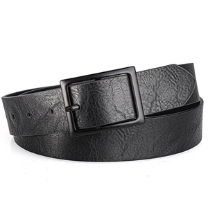 Detail of vintage black PU leather belt with matte buckle and unique cracked texture