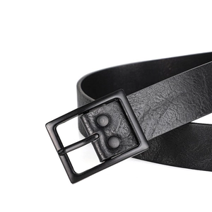 Detail macro shot of black PU leather belt texture and square matte black metal pin buckle